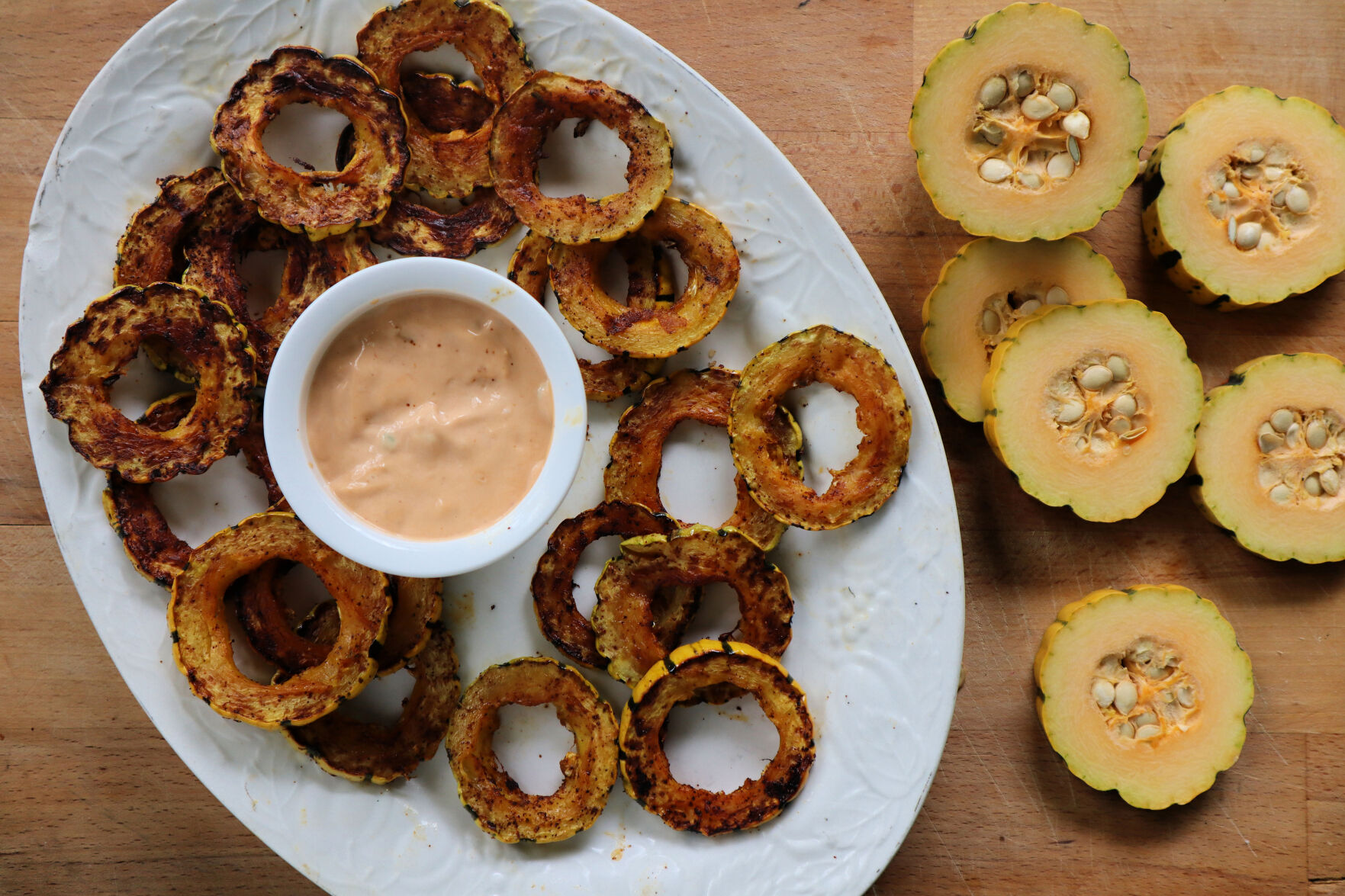Rounds of roasted delicata squash are dusted in warm spices and served with a spicy chipotle mayo.